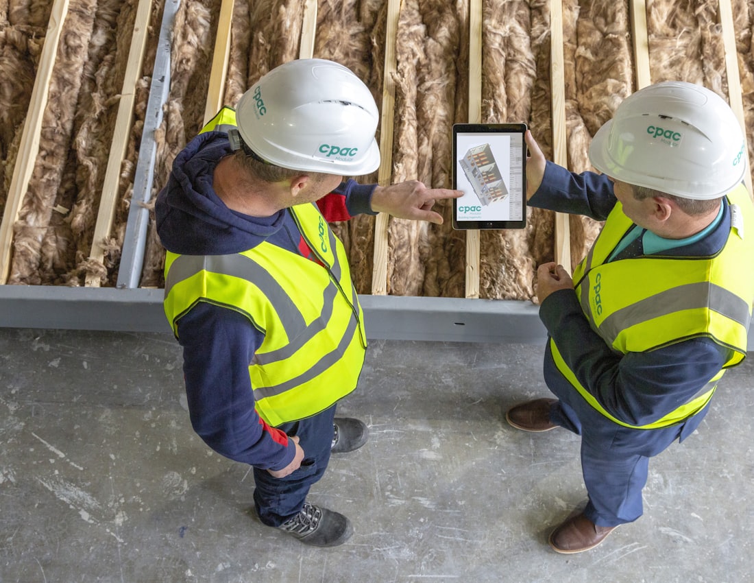 Construction professionals reviewing project plans together, representing verification and approval before payment
