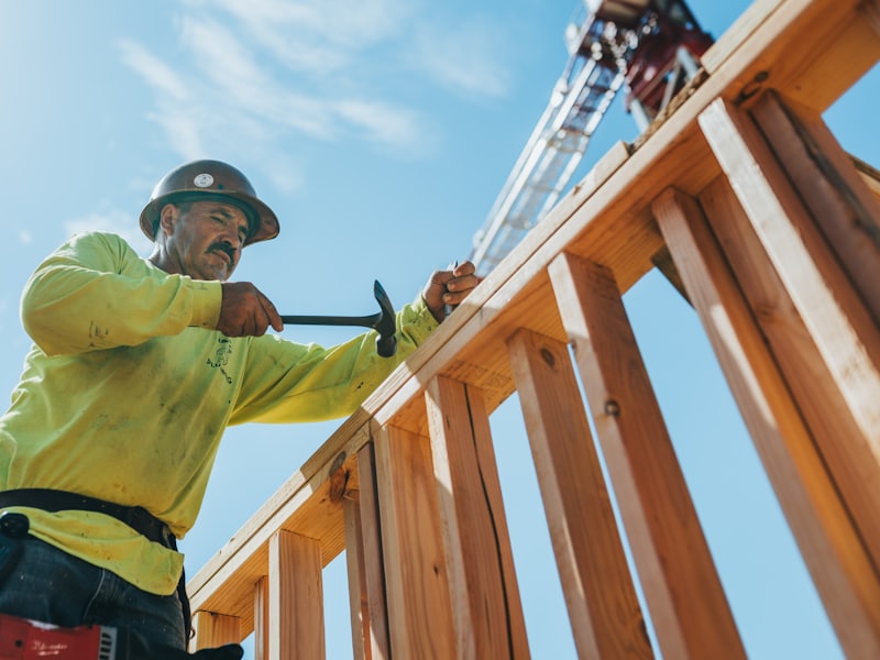 Contractor fixing timber roof trusses on a residential build