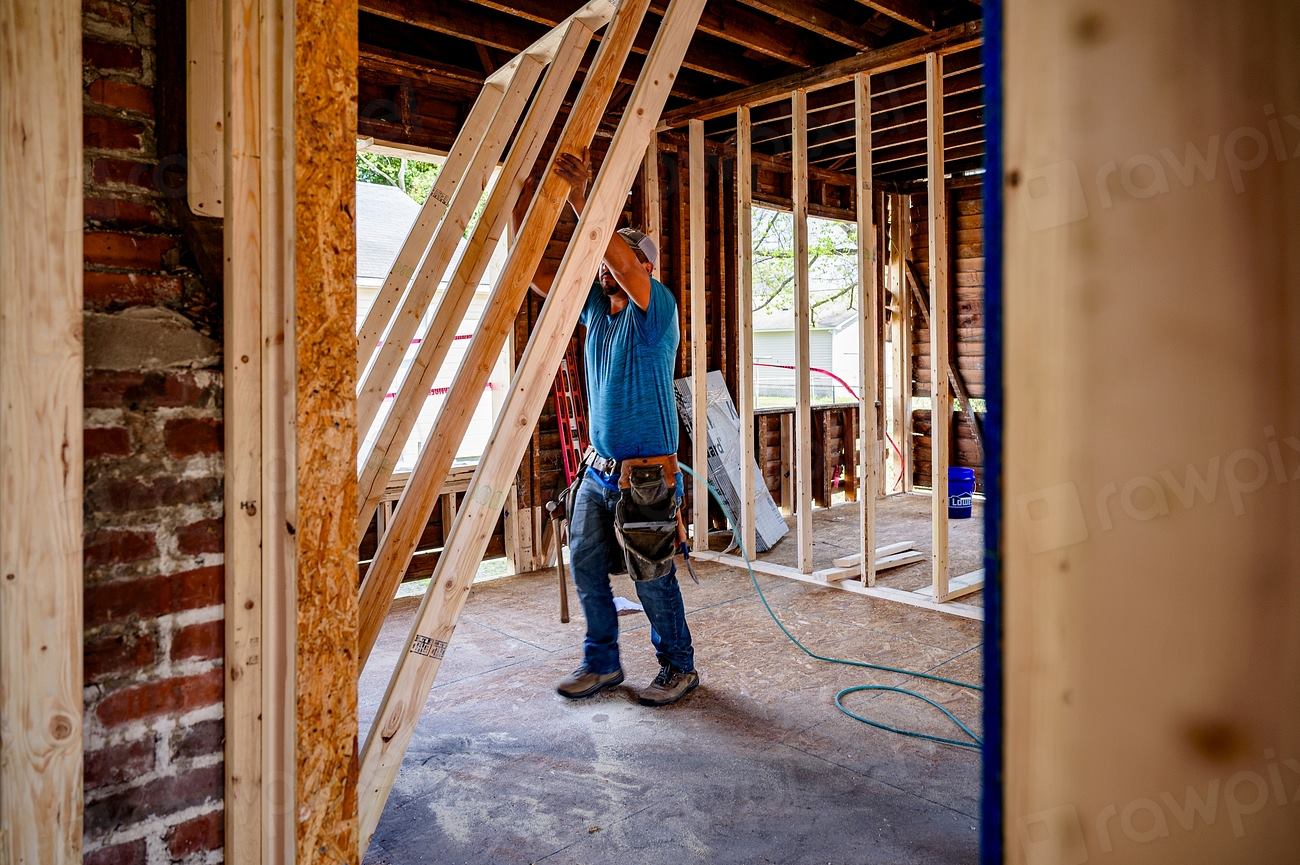 Tradesperson working on a residential frame at the stage where a progress claim would be verified and approved