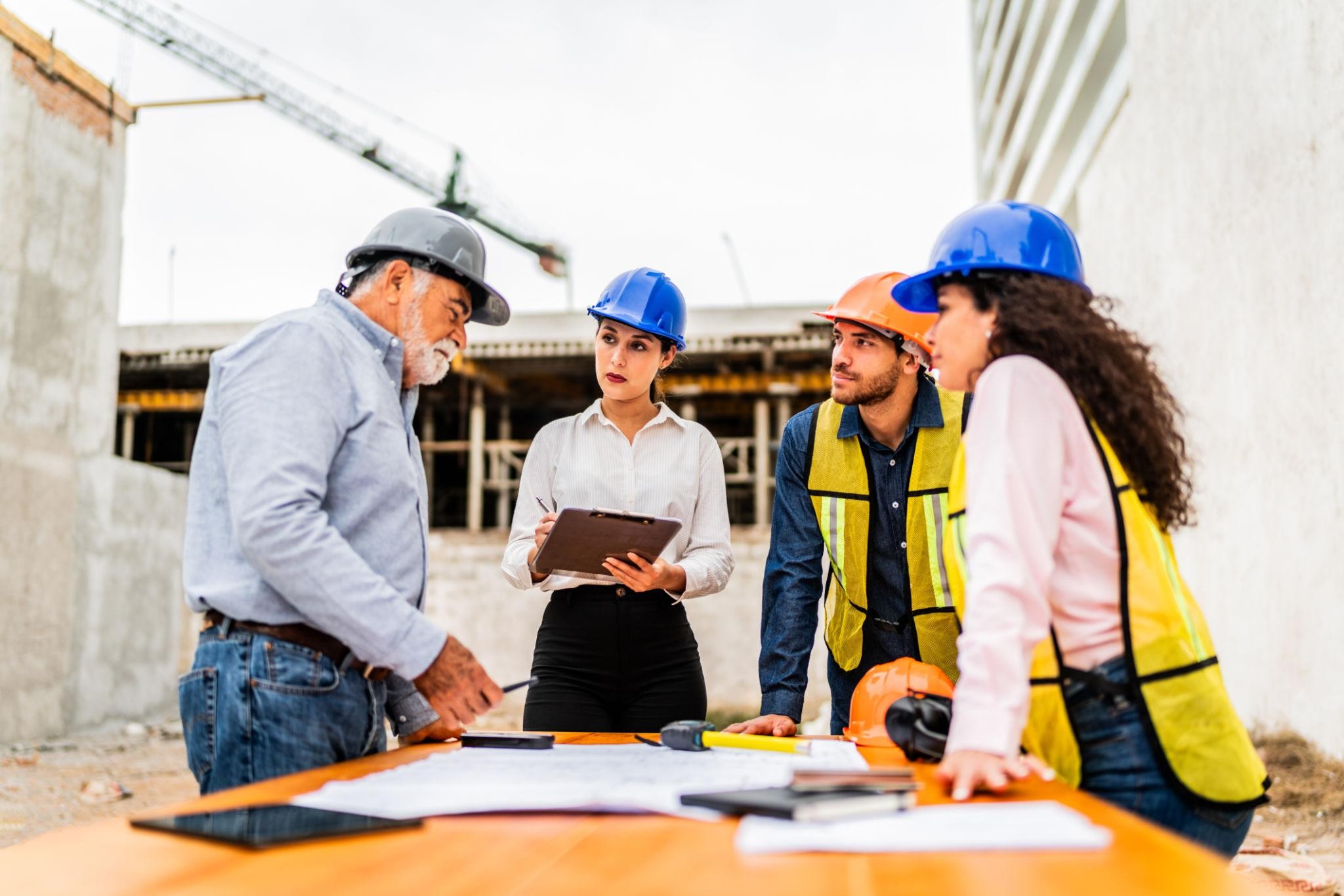 Construction team reviewing blueprints and project documentation across multiple concurrent builds